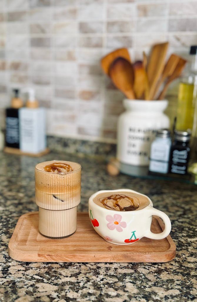 Warm and inviting kitchen scene featuring latte art in decorative mugs on a wooden tray.